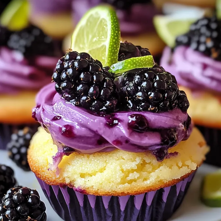 A cupcake with a blackberry and lime on top.