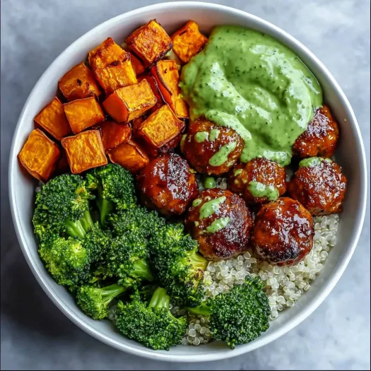 A bowl of food with meatballs, broccoli, and avocado.