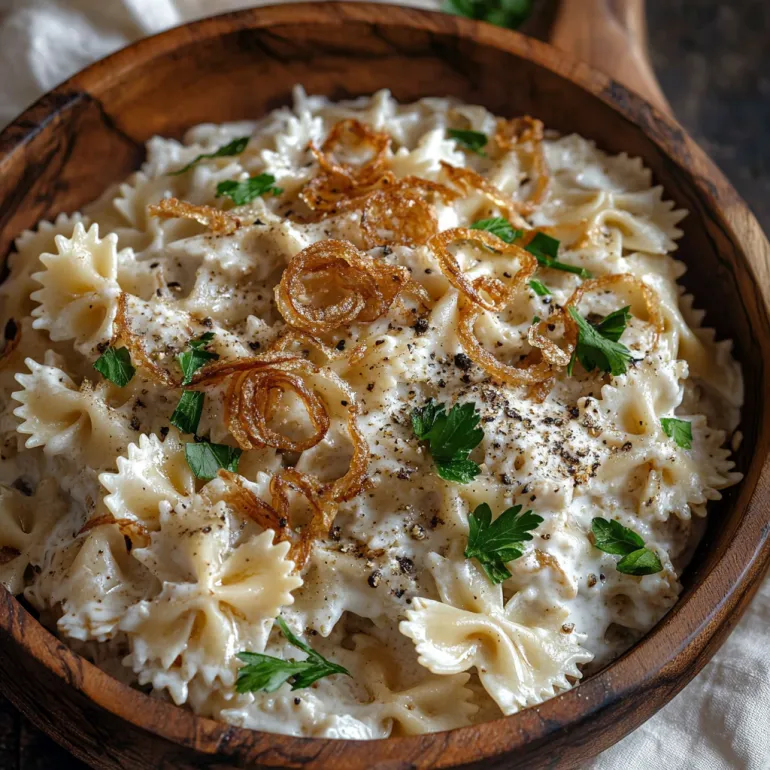 A bowl of pasta salad with onions.