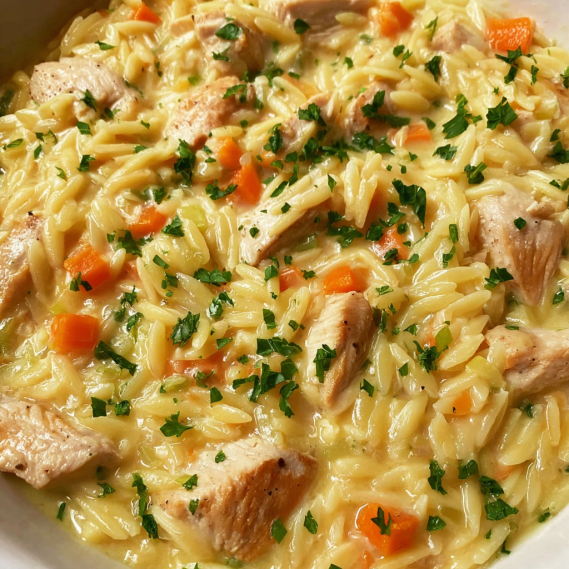 A bowl of soup with chicken and carrots.