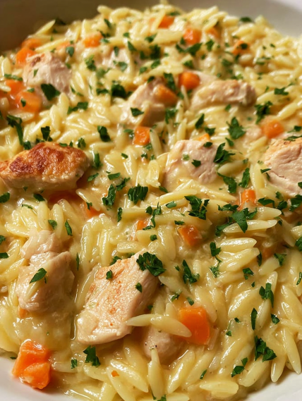 A close up of a dish with chicken and carrots.