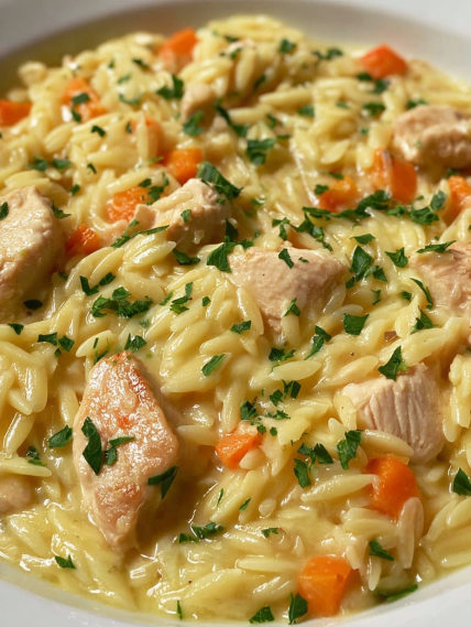 A bowl of pasta with chicken and carrots.