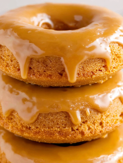 Three donuts with glaze dripping off.
