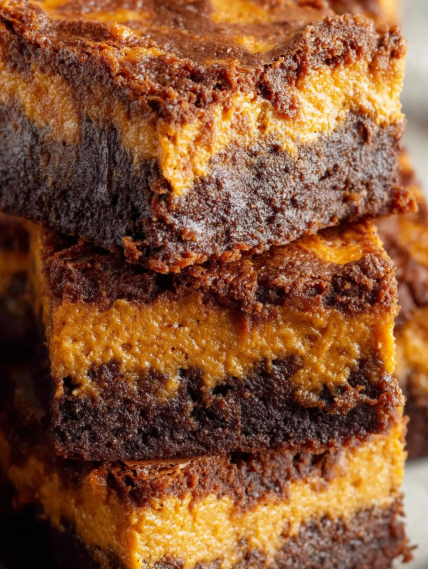 A stack of brownies with caramel topping.