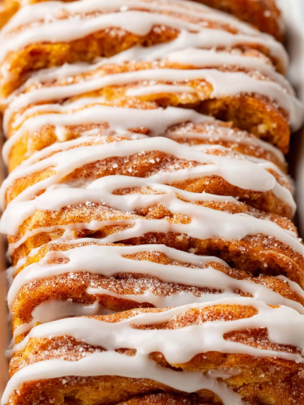 A stack of cinnamon rolls with white icing.