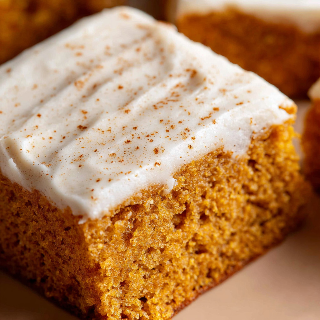 A slice of cake with white frosting and orange cake.