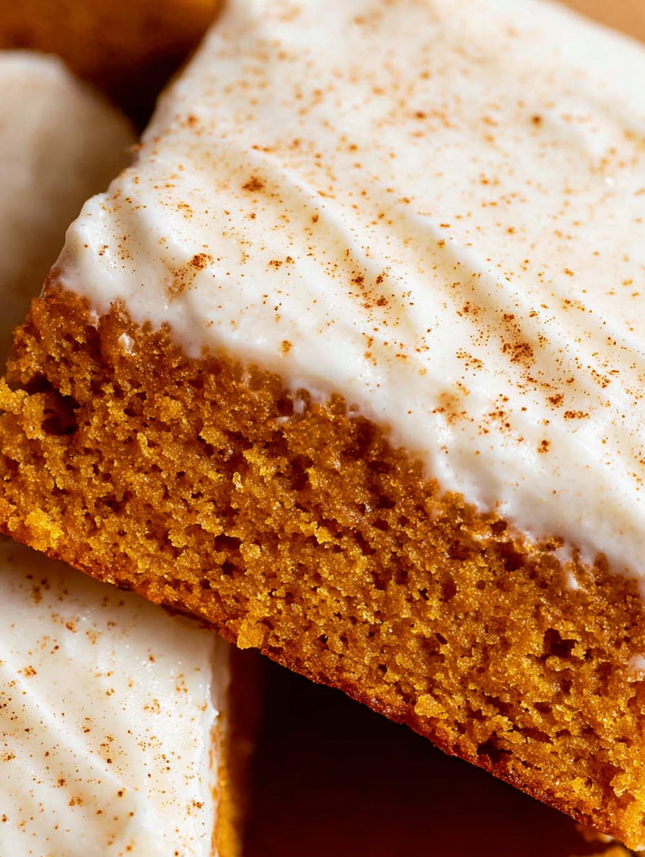 A slice of cake with white frosting and orange cake.
