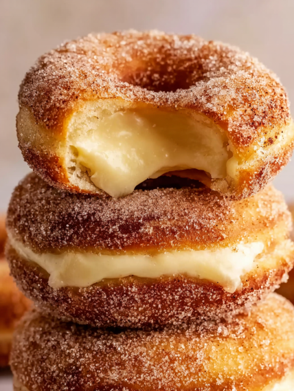 A stack of donuts with powdered sugar on top.