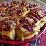 A plate of cinnamon rolls with bacon on top.